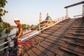 Smiling muslim man with bicycle across wooden bridge over the ca